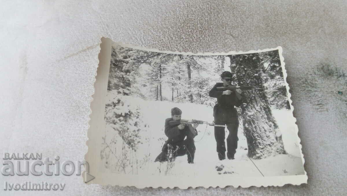 Photo Two soldiers with machine guns in the forest in winter