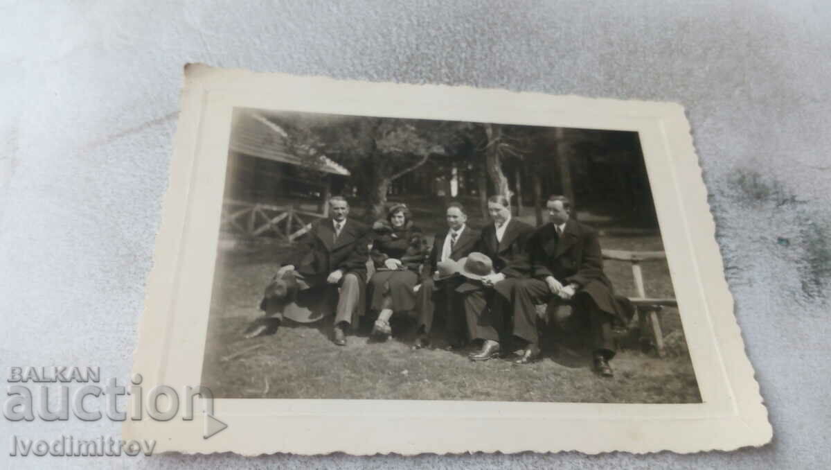 Photo Four men and a woman on a bench in the forest