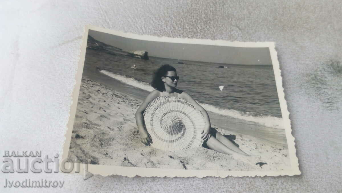 Foto Femeie cu o pălărie cu boruri largi pe plajă