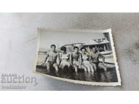 Ms. Two women and three young men on a wooden pier in the sea