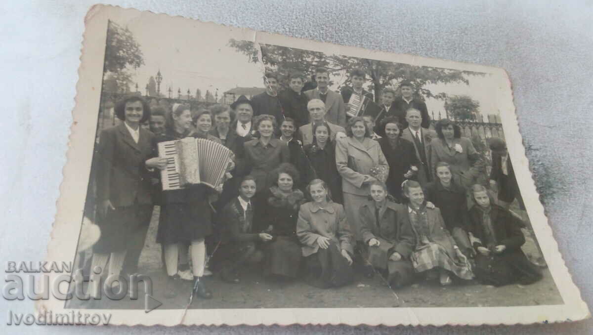 Foto Studenți cu profesorii lor și o fată cu acordeon