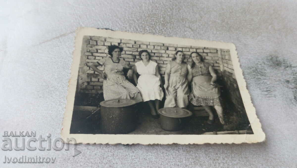 Picture Four women next to two large pots