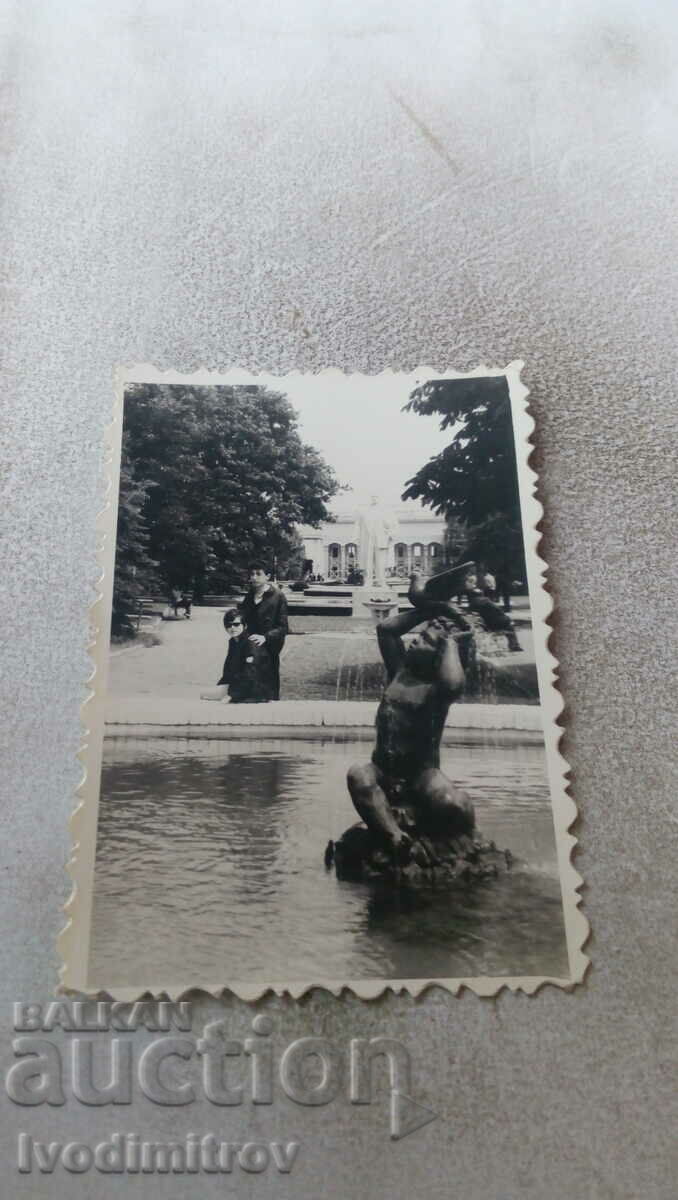 Photo A young man and a girl by a fountain