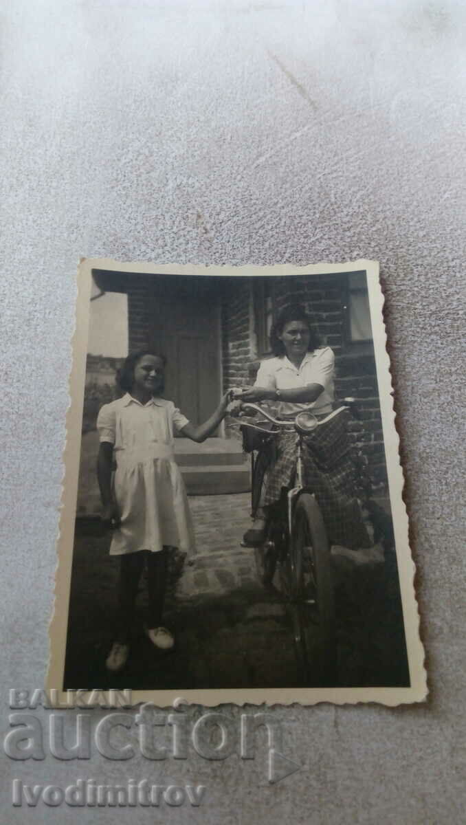 Foto Fată și femeie cu o bicicletă de epocă