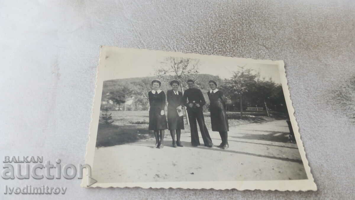 Φωτογραφία Ένας νεαρός άνδρας και τρία νεαρά κορίτσια στο πάρκο