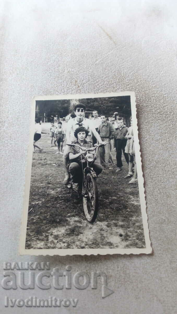 Fotografie Un tânăr și o fată cu o bicicletă de epocă