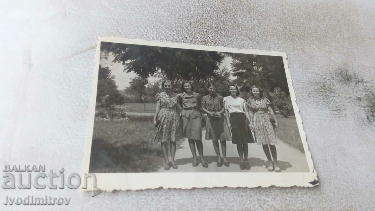 Imagine Cinci fete tinere pe o alee din parc