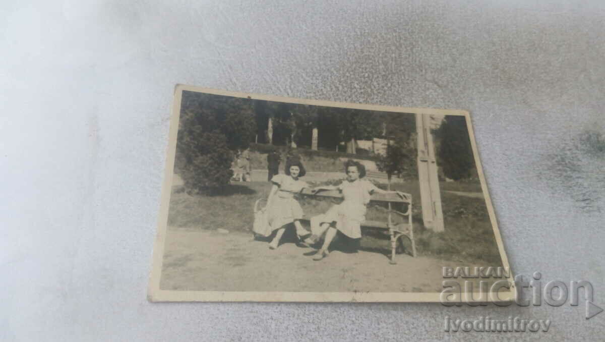 Φωτογραφία Δύο νεαρές γυναίκες σε ένα παγκάκι στο πάρκο