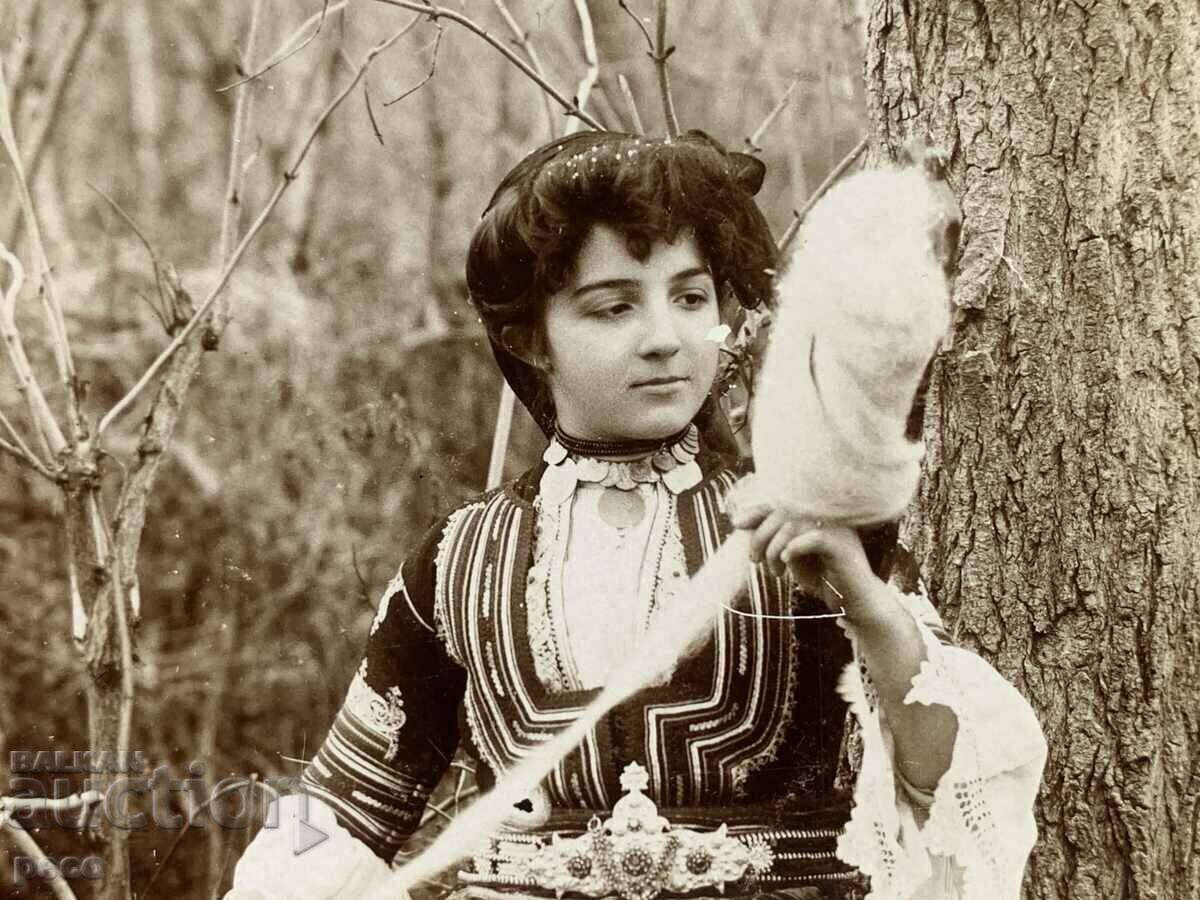 Delivery of A beautiful Bulgarian woman in a Kyustendil costume before wearing a hurka, 1906.