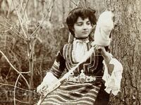 Красива българка с кюстендилска носия преде с хурка 1906 г.