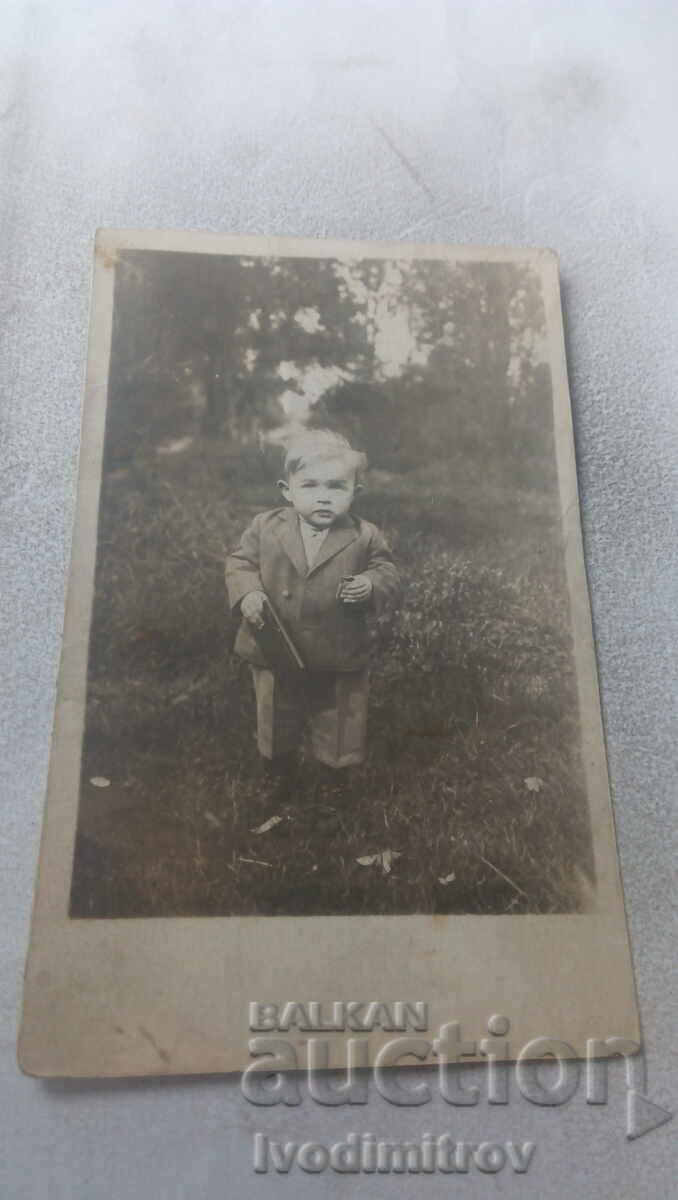 Φωτογραφία Μικρό αγόρι που κρατά ένα μαύρο σημειωματάριο