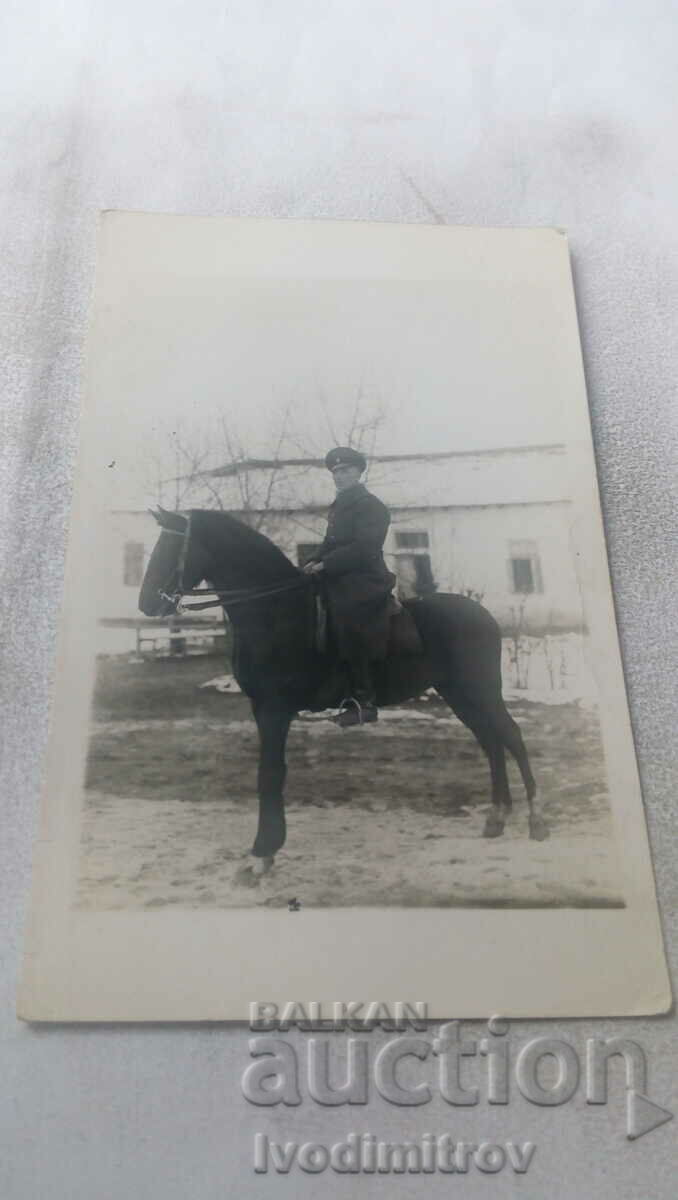 Ofițer foto pe un cal negru iarna