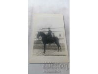 Αξιωματικός φωτογραφιών σε μαύρο άλογο το χειμώνα