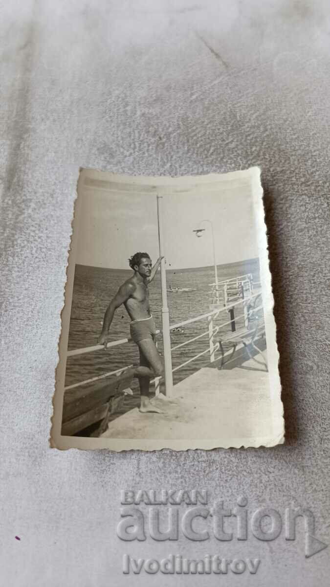 Photo Young man in a swimsuit on the pier