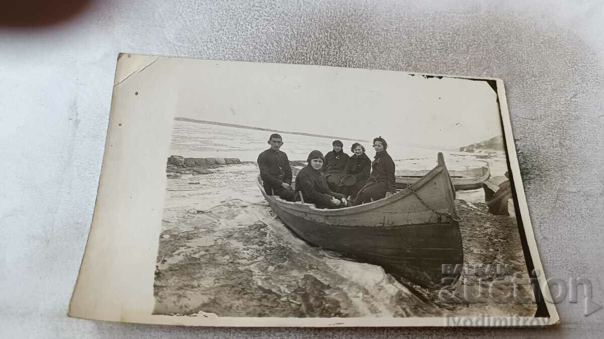 Photo Four women and a boy in a boat on the seashore
