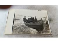 Φωτογραφία Τέσσερις γυναίκες και ένα αγόρι σε μια βάρκα στην ακτή
