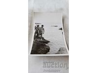 Снимка Двама мъже по бански на скала на брега на морето