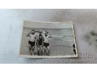 Photo Three men in swimsuits on the beach
