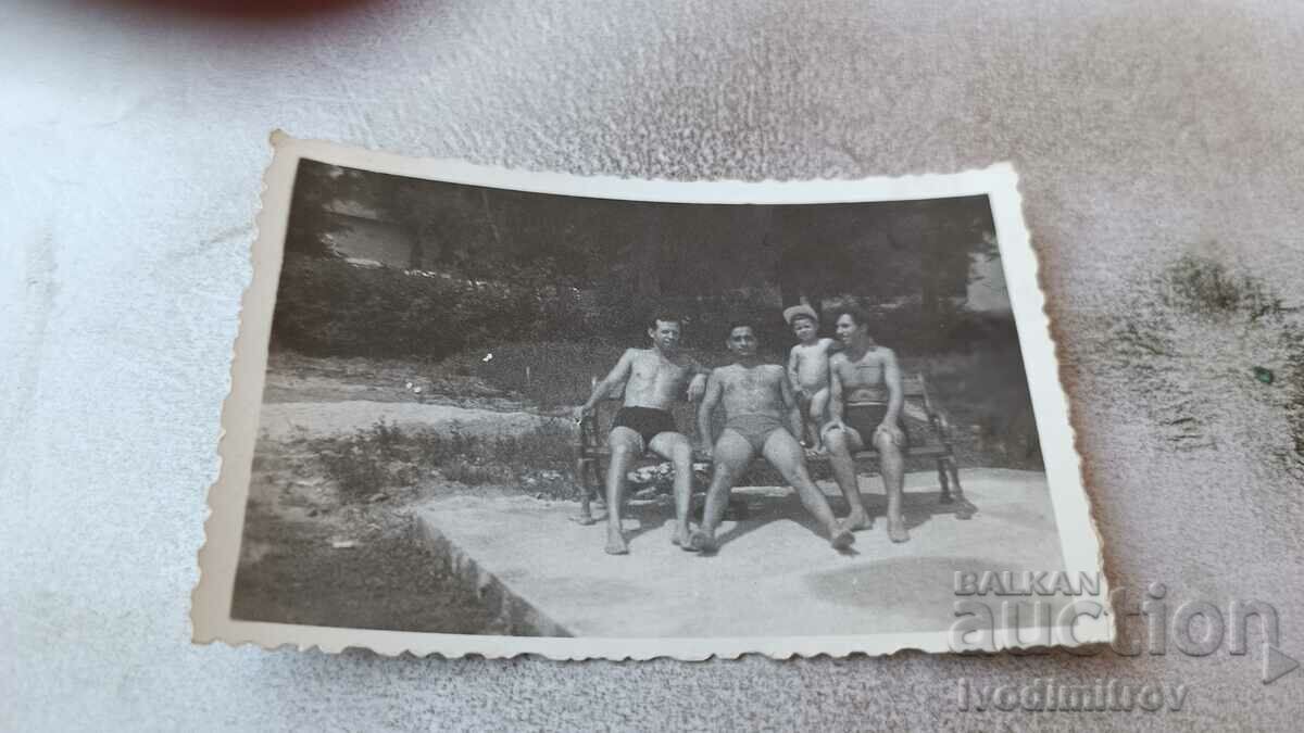 Снимка Трима мъже и малко моченце по бански на пейка в парка