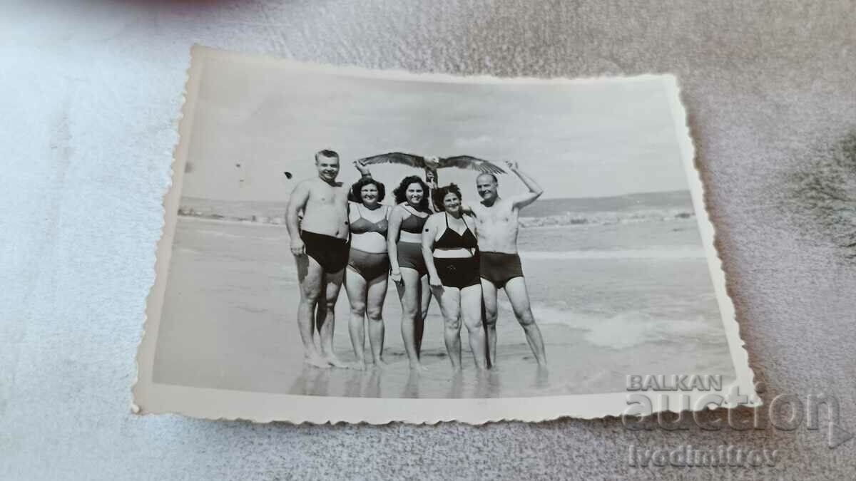 Foto Doi bărbați și trei tinere pe plajă
