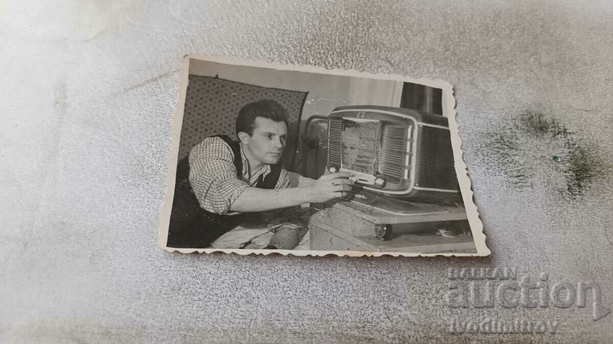 Снимка Млад мъж с ретро радиопремник в стая