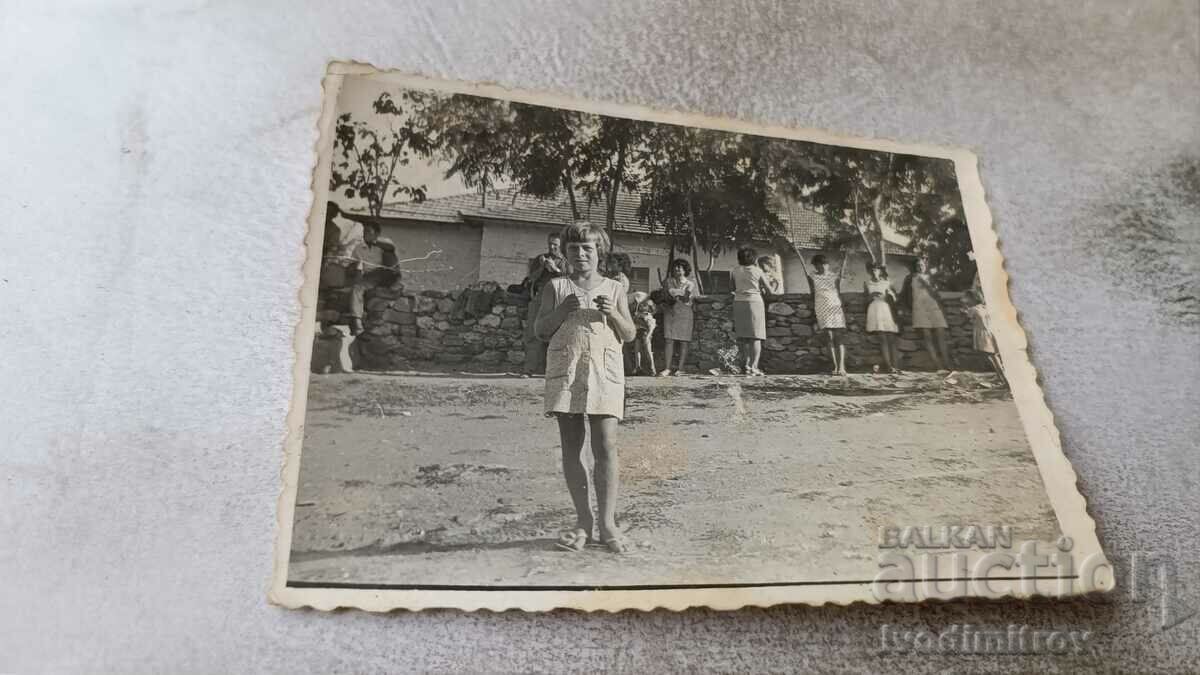 Foto Fată într-o rochie albă în curtea școlii