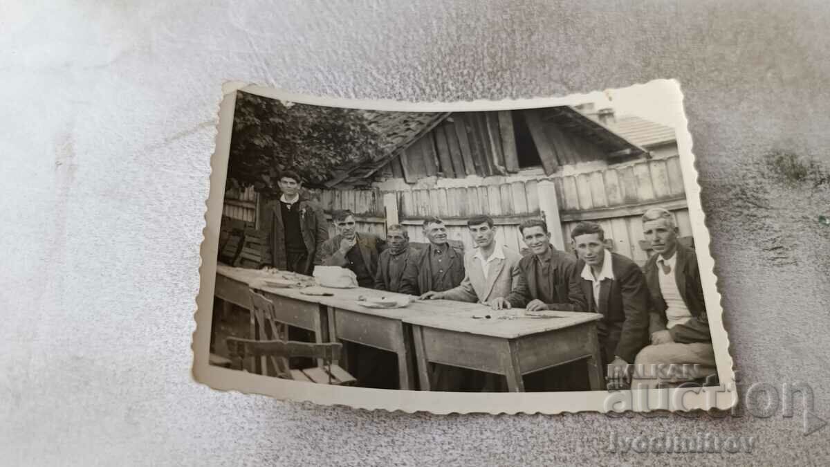 Φωτογραφία Άνδρες σε ξύλινα τραπέζια