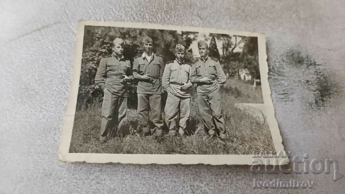 Photo Four soldiers smoking a cigarette in the park