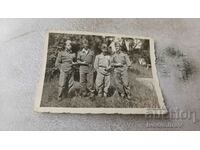 Φωτογραφία Τέσσερις στρατιώτες που καπνίζουν ένα τσιγάρο στο πάρκο