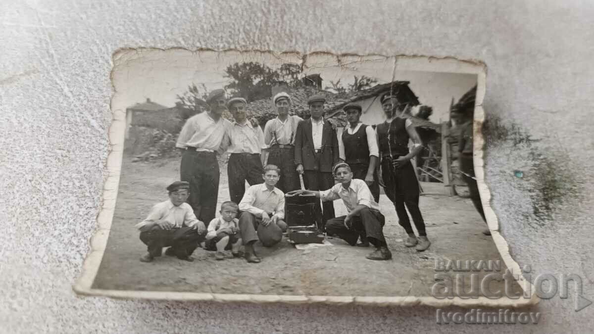 Photo Men and two boys with a vintage gramophone on the street