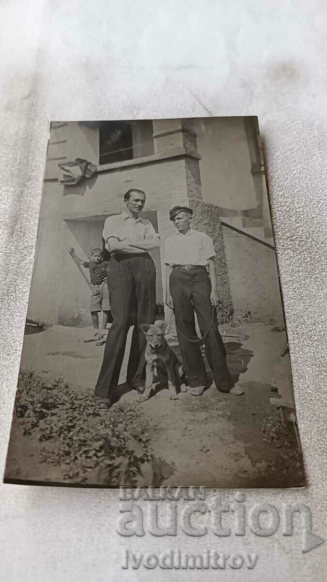 Снимка Мъж младеж момче и малко кученце на улицата