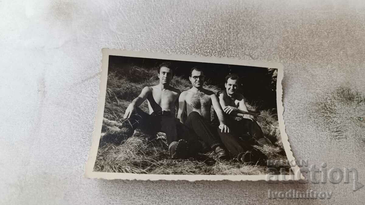 Foto Trei bărbați goi până la brâu stând pe gazon