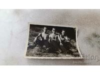 Снимка Трима мъже голи до кръста седнали на поляната