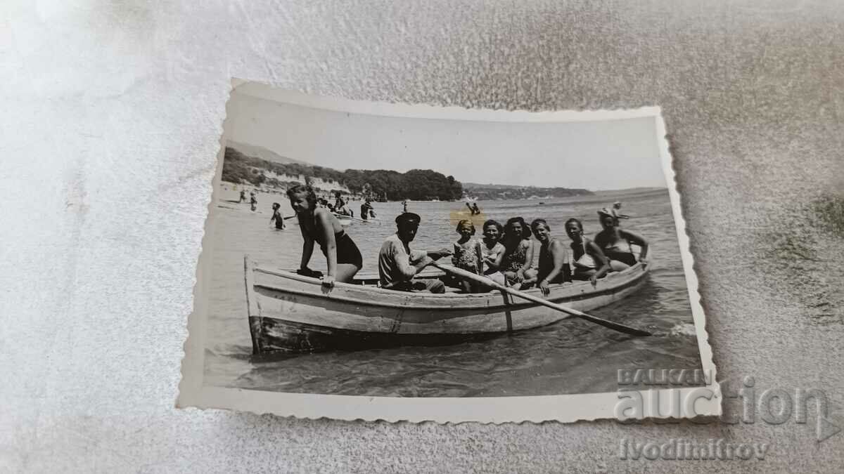 Photo Men and women in a boat for walks on the seashore