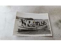 Fotografie Bărbați și femei într-o barcă pentru plimbări pe malul mării
