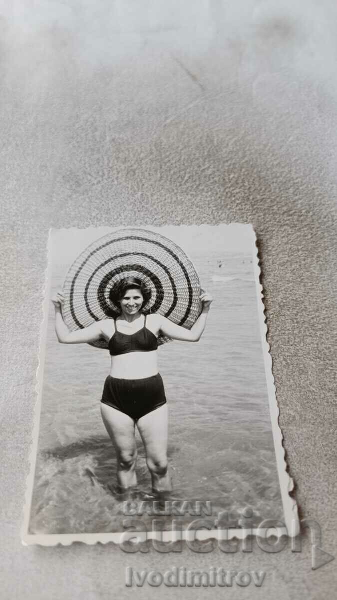 Φωτογραφία Νεαρή γυναίκα με φαρδύ καπέλο στην παραλία