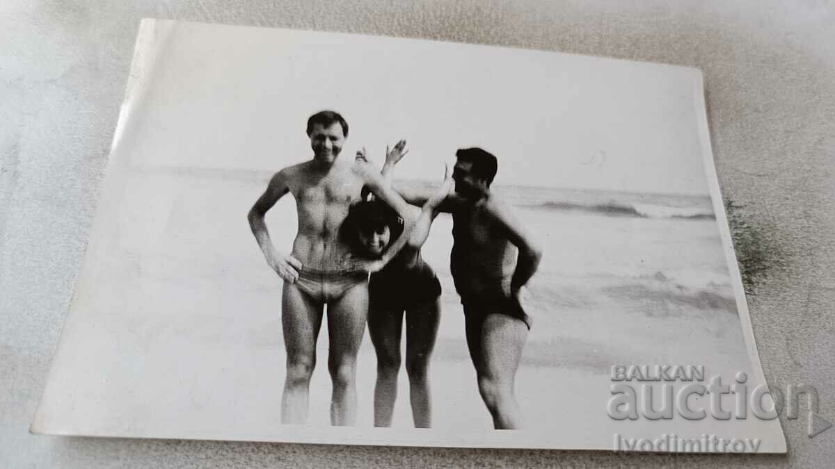 Fotografie Prietenie Doi bărbați și o fată tânără pe plajă