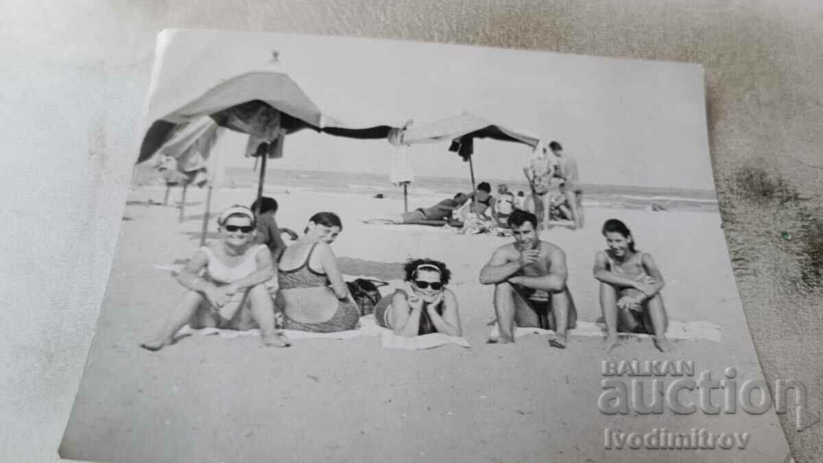 Photo A man and four women on the beach
