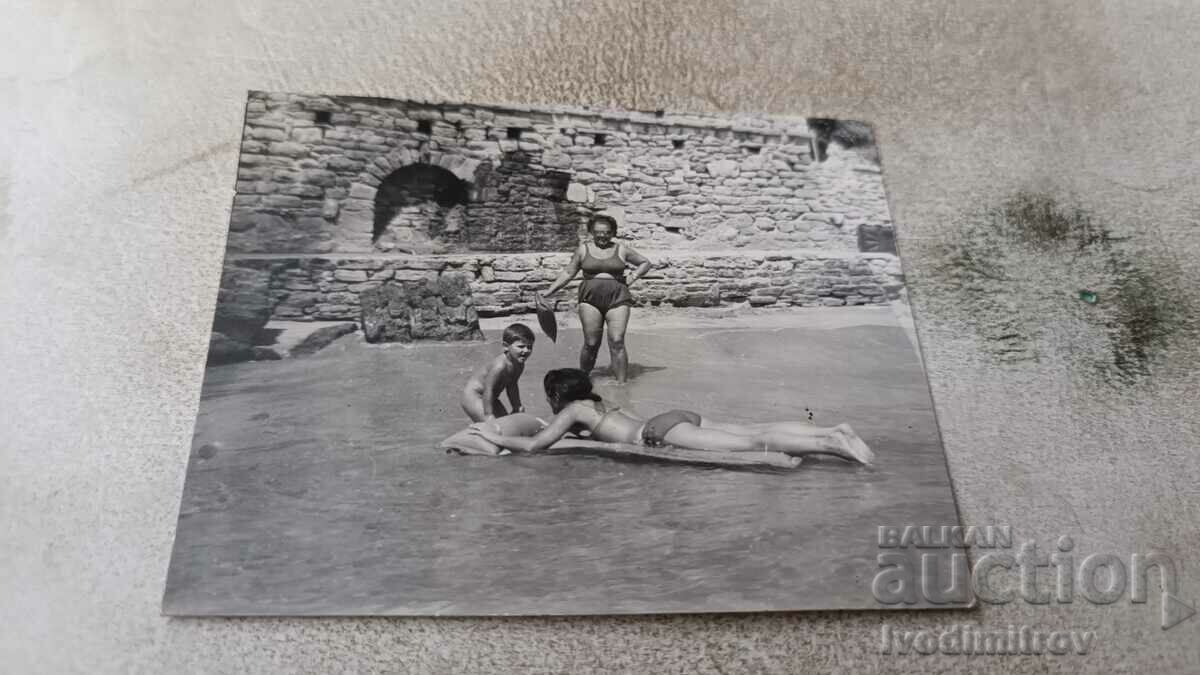 Foto Două femei și un băiețel cu o saltea gonflabilă în mare