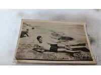 Снимка Мъж с ретро бански лежащ на брега на морето