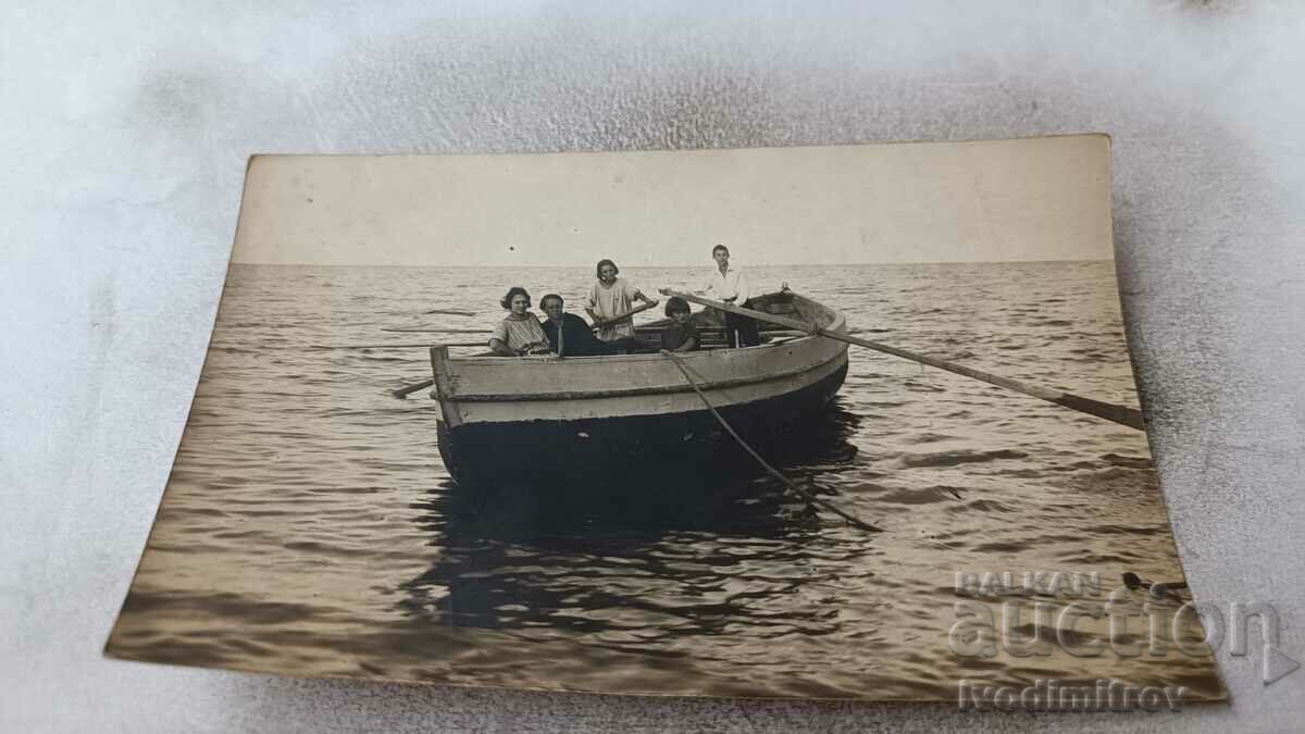 Photo Man, woman and three children with a boat in the sea