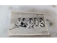 Снимка Младежи и млади жени по бански седнали на поляната