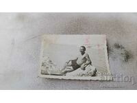 Fotografie Un bărbat în costum de baie retro pe o stâncă lângă mare