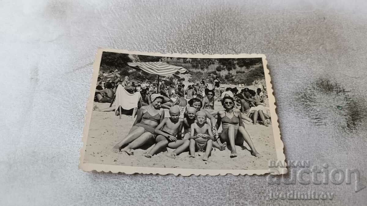 Foto Trei femei și trei copii pe plajă