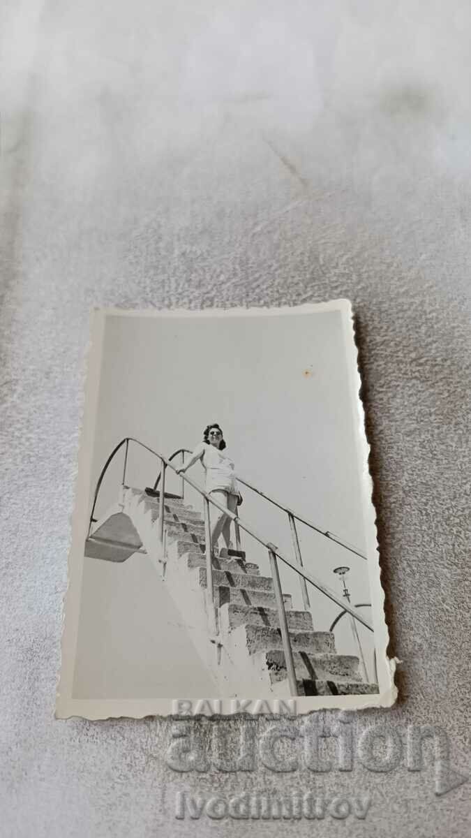 Снимка Млада жена на стълбичка на басейн