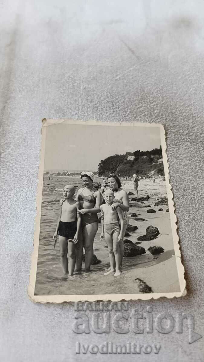 Fotografie Două femei și doi băieți pe plajă