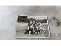 Fotografie Șapte bărbați pe o stâncă pe malul mării