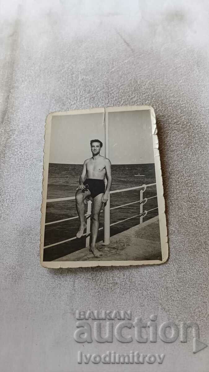 Photo A man in a vintage swimsuit on the pier