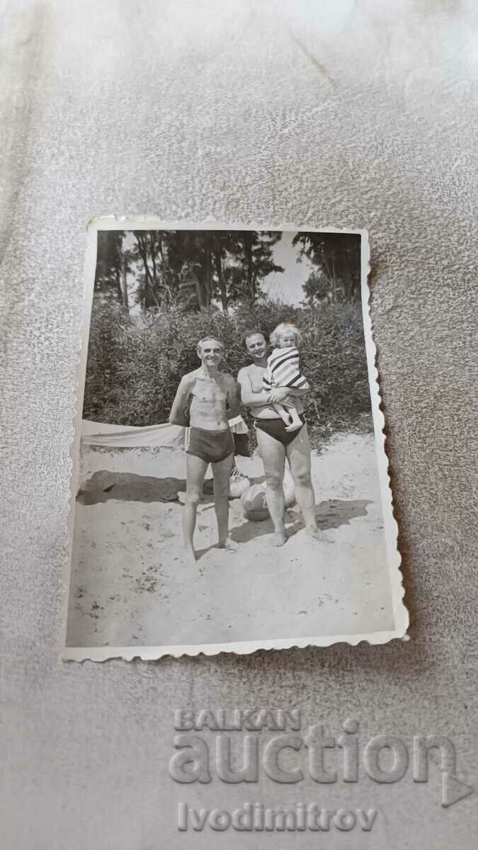 Photo Two men and a little girl on the beach