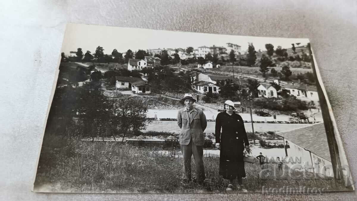Photo Man and woman in front of a group of villas